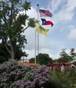 La Hacienda's American, Texas, and La Hacienda Flag in the breeze