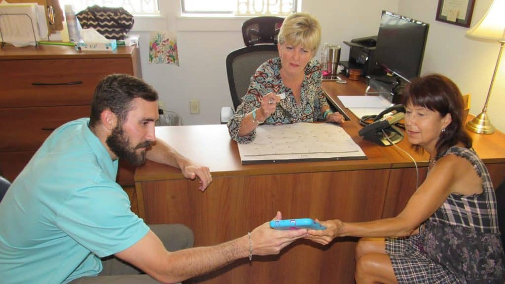 Utilization Review Specialist Ryan McBride, Case Manager Dana Muhlberg, and Continuing Care Counselor Linda Bertel share information which will help a patient have a successful recovery after leaving La Hacienda.