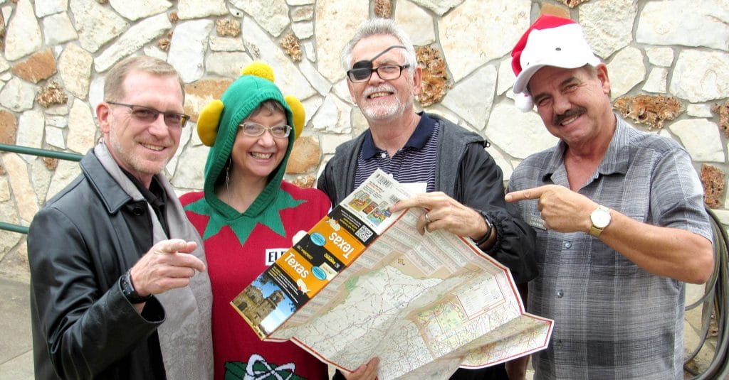 Dale, Sabine, Chris and Clay check the map for travel to alumni Christmas parties around the state